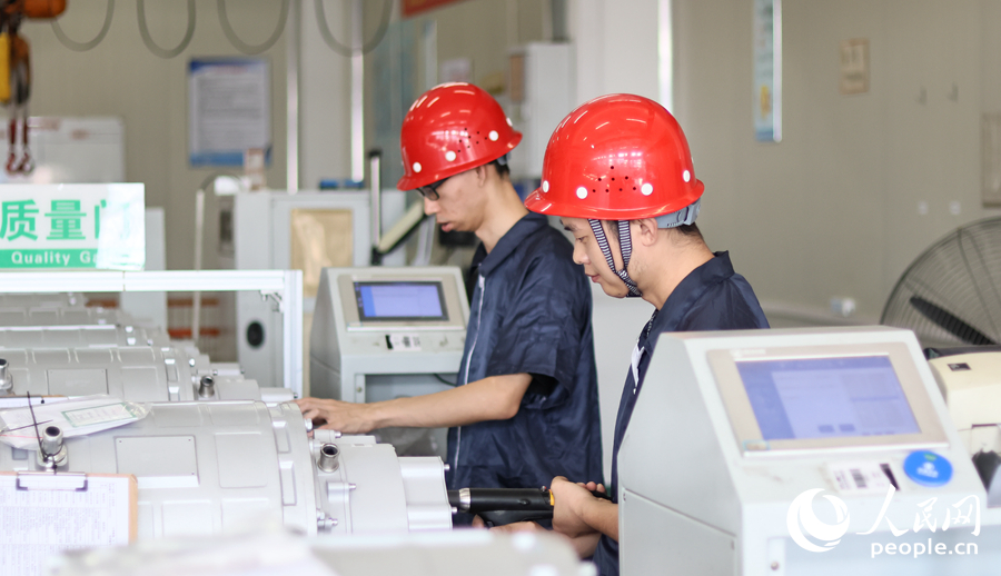 金龍新能源的技術(shù)工人在進(jìn)行電機(jī)電控關(guān)鍵技術(shù)組裝。人民網(wǎng) 李昌乾攝